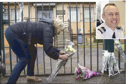  ?? AP ?? A woman places flowers at the main gate of the police headquarte­rs in Carcassonn­e on Saturday, following an attack at a supermarke­t in Trebes, France yesterday. Inset shows slain police officer Arnaud Beltrame.