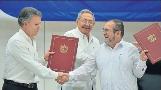  ?? ADALBERTO ROQUE / AFP ?? El president de Colòmbia, Juan Manuel Santos, i el cap de les FARC,Timoleón Jiménez, encaixen sota el somriure de Raúl Castro