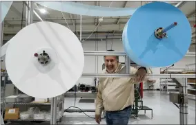  ?? JEFF ROBERSON/ASSOCIATED PRESS ?? Angstrom Manufactur­ing president Chris Carron poses for a photo with machinery the company uses to make surgical masks Wednesday, March 23, 2022, in Ste. Genevieve, Mo. Angstrom normally makes dental equipment but expanded with the help of a grant during the pandemic to produce personal protective equipment, churning out millions of surgical-style masks.