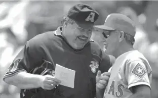  ?? Associated Press ?? n This June 8, 1997, file photo shows home plate umpire Ken Kaiser, left, and Texas Rangers manager Johnny Oates go over the lineup before a baseball game against the Kansas City Royals in Kansas City, Mo.