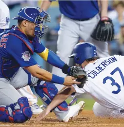  ?? (Reuters) ?? LOS ANGELES DODGERS baserunner Charlie Culberson scores against Chicago Cubs catcher Willson Contreras (left) in an initial out call that was overturned on a replay challenge in the seventh inning of the Dodgers’ 5-2 home victory over the Cubs in...