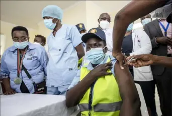  ?? Ben Curtis/Associated Press ?? A Kenyan hospital security guard receives one of the country's first COVID-19 vaccinatio­ns Friday at Kenyatta National Hospital in Nairobi, Kenya. As many African nations got their first shipments of the vaccine Friday via the global COVAX program, officials noted that the millions of people there will need many more doses to arrive in the coming months.