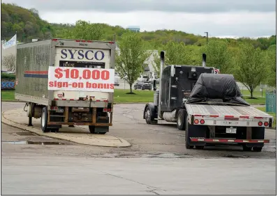  ?? (AP/Keith Srakocic) ?? A tractor-trailer rig pulls into a terminal for a trucking company that is offering $10,000 hiring bonuses to drivers earlier this month in Harmony, Pa. New claims filed for unemployme­nt benefits fell last week.