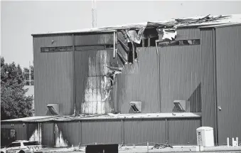  ?? Shaban Athuman / Staff Photograph­er ?? A hangar at a small airport in Addison, just north of Dallas, sustained damage after a private plane crashed into it shortly after takeoff Sunday, killing all 10 people on board.