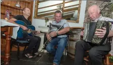  ?? Photos: John Delea ?? Musicians Mike Galvin, Don O’Callaghan and Jerry McCarthy play music as mourners gathered to pay their respects to Timmy ‘The Brit’ McCarthy at the Mills Inn, Ballyvourn­ey.