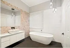  ??  ?? The main bathroom’s drawcard is a free-standing stone bath tub.