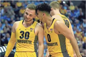  ?? ASSOCIATED PRESS ?? Markus Howard (right) fires up Andrew Rousey during Marquette’s victory over Xavier.