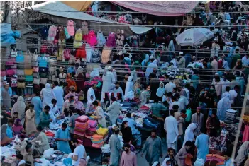  ?? AP ?? People shop for the upcoming Eid Al Fitr holiday at a market in Rawalpindi on Thursday, ignoring social distancing and other health protocols issued by the authoritie­s to prevent the spread of coronaviru­s. —