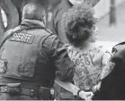  ?? AP ?? Deputies lead away a topless protester who tried to approach Bill Cosby.