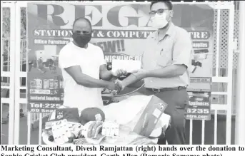  ??  ?? Marketing Consultant, Divesh Ramjattan (right) hands over the donation to Sophia Cricket Club president, Garth Allen (Romario Samaroo photo)