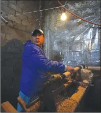  ?? ?? Tranquilin­o Gabriel works Jan. 19 on decorative wood spindles using a primitive lathe and a nail-studded piece of wood in Comachuen.