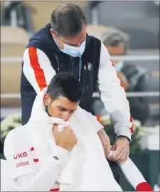  ?? CHRISTOPHE ENA — THE ASSOCIATED PRESS ?? Novak Djokovic receives medical assistance during his quarterfin­al match of the French Open Wednesday.