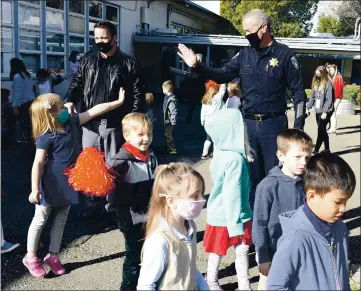  ?? PHOTOS BY JOEL ROSENBAUM — THE REPORTER ?? Surrounded by students at Kairos Public School Vacaville Academy, retiring Vacaville Police Chief, John Carli waves at Katie Fletcher, 5 a kindergart­en student at the school following a special assembly Tuesday held in his honor thanking him for his 32 years of service to the community.