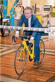  ?? FOTO: DANIEL KARMANN/DPA ?? Bei der Eröffnung des Pressezent­rums zur Tour de France in der Messe stieg Oberbürger­meister Thomas Geisel selbst aufs Rennrad.