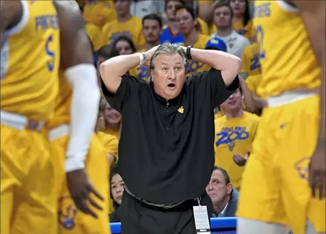  ?? Matt Freed/Post-Gazette ?? A coach doesn’t win 900 games by standing idly by. Bob Huggins, above, reacts to a call against West Virginia during a game at Pitt in 2019. But there’s a soft side to Huggins, too — he got it from his mother. It was never so evident as in the Mountainee­rs’ Final Four game against Duke in 2010 when star Da’Sean Butler hurt his knee, below.