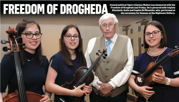  ??  ?? Famed political figure Séamus Mallon was honoured with the Freedom of Drogheda last Friday. He is pictured with triplets Elizabeth, Katie and Sophie Ní Mhaoláin, who performed at the ceremony for Séamus at the Highlanes Gallery.