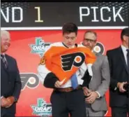  ?? MICHAEL AINSWORTH — THE ASSOCIATED PRESS ?? Jay O’Brien, second from left, puts on a Flyers jersey after being selected No. 19 overall in the first round by the Flyers Friday night in Dallas.