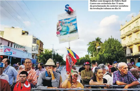  ??  ?? Mulher com imagem de Fidel e Raúl Castro em cerimónia dos 75 anos da proclamaçã­o do carácter socialista da revolução cubana no dia 16