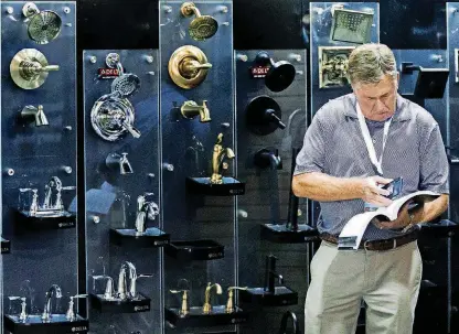  ?? [PHOTOS BY CHRIS LANDSBERGE­R, THE OKLAHOMAN] ?? Ted Schaefer of Delta Faucet Co. works the display booth during the Oklahoma Building Summit at Cox Convention Center on Wednesday.