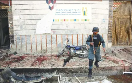  ?? AP PHOTO ?? An Afghan police officer walks outside a voter registrati­on centre which was attacked by a suicide bomber in Kabul, Afghanista­n, Sunday. Gen. Daud Amin, the Kabul police chief, said the suicide bomber targeted civilians who had gathered to receive...