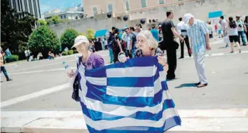  ?? — AFP ?? Women hold a Greek flag as they take part in a demonstrat­ion in Athens against the agreement reached to resolve a 27-year name row with Macedonia has kicked up a political storm in Greece.