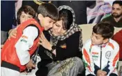  ??  ?? J&K Chief Minister Mehbooba Mufti hugs 7-year-old Hashim Manzoor, who recently won Asian Karate Championsh­ip, at the Indoor Stadium in Srinagar on Tuesday