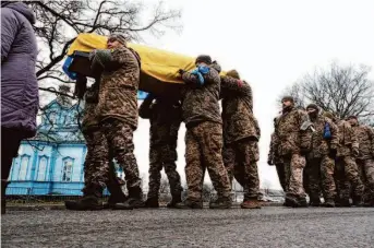  ?? Spencer Platt/Getty Images ?? Ukrainian soldiers carry the casket of their comrade Sergiy Sochenko at his funeral near Rohoziv. Sochenko was killed battling Russian forces in the eastern Donetsk region.