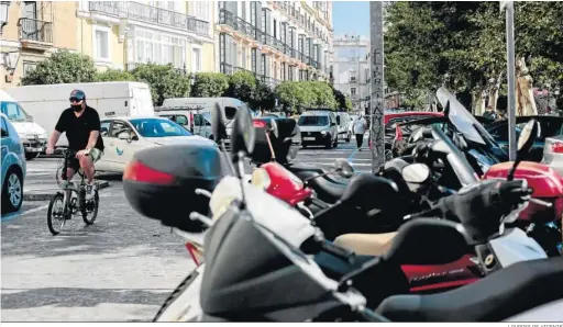  ?? LOURDES DE VICENTE ?? Una de las vías laterales de la plaza en la mañana de ayer, colapsada por el tráfico rodado y por los coches y motos estacionad­as.