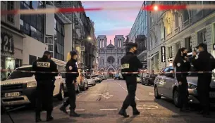  ?? DANIEL COLE THE ASSOCIATED PRESS ?? Police work near the Notre Dame church in Nice, southern France, after a knife attack took place on Thursday. A young Tunisian man suspected of the attack was seriously wounded by police.