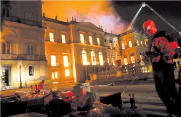  ?? — Reuters photo ?? People rescue items during a fire at the National Museum of Brazil in Rio de Janeiro.