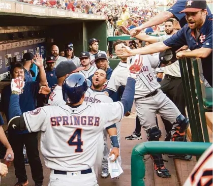  ?? Tim Sharp / Associated Press ?? George Springer (4) gets the royal treatment from his Astros teammates after slugging a leadoff home run off Rangers pitcher Yu Darvish during the first inning of Wednesday night’s 3-1 victory at Globe Life Park.
