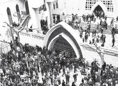  ?? AP ?? Relatives and onlookers gather outside a church after a bomb attack in the Nile Delta town of Tanta, Egypt, Sunday, April 9. The attack took place on Palm Sunday, the start of the Holy Week leading up to Easter, when the church in the Nile Delta town...