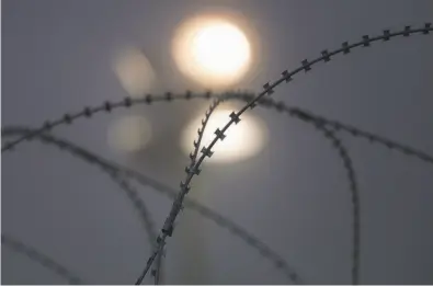  ?? John Moore / Getty Images ?? Razor wire lines the U.S.-Mexico border area in Donna, Texas. President Trump ordered military troops to the border ahead of midterm elections, reminding voters of his hot-button approach to immigrants.
