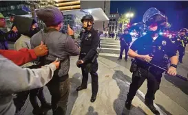  ?? (AFP) ?? Protesters face off with a line of police officers during a rally against the fatal police assault of Tyre Nichols, outside the LAPD headquarte­rs, in Los Angeles, California, on Friday