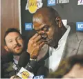  ?? MARK J. TERRILL/ASSOCIATED PRESS ?? Magic Johnson wipes his eyes as he speaks to reporters prior to Tuesday’s game between the Lakers and the Trail Blazers in Los Angeles. Johnson abruptly quit as the Lakers’ president of basketball operations Tuesday.