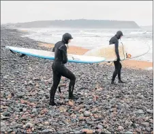  ?? ANDREW VAUGHAN/THE CANADIAN PRESS ?? Daniel Fahie and his 15-year-old daughter Miranda head to the water at Lawrenceto­wn Beach in East Lawrenceto­wn, N.S.