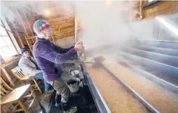  ?? KRISTOPHER RADDER/THE BRATTLEBOR­O REFORMER 2020 ?? Beverly Thurber checks sap being boiled for maple syrup in Vermont. Some states are holding scaled-back celebratio­ns this year.