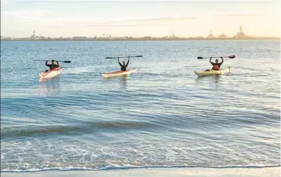  ?? LINDA GOEBEL/COURTESY ?? DAY 8: Patrick Connolly, Greg Pflug, center, and Fred Goebel celebrate the end of a 310-mile kayaking trip at the finish line, Huguenot Memorial Park, where the St. Johns River meets the Atlantic Ocean.