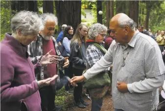  ?? Photos by Patrick Tehan / Special to The chronicle ?? Valentin Lopez, chair of the Amah Mutsun Tribal Band (right), blesses attendees with burning sage at the removal of a mission bell marker from the UC Santa Cruz campus.