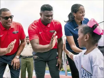  ?? Associated Press ?? McKeesport’s Swin Cash, now vice president of basketball operations for the New Orleans Pelicans, joins coach Alvin Gentry, left, and heralded rookie Zion Williamson at a ribboncutt­ing ceremony for the re-opening of a playground court in New Orleans.