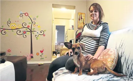  ?? STEVE RUSSELL/ TORONTO STAR ?? Sarah Bankuti sits in her small one-bedroom apartment with her dog Tiberius. Bankuti and her husband, John, were denied a chance at an affordable three-bedroom unit because their combined income was too high. But her income isn’t guaranteed, she says, and there’s no appeal process.