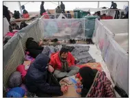  ?? (AP/Kemal Softic) ?? People sit in a temporary shelter Saturday at the destroyed Lipa migrant camp in northweste­rn Bosnia, near the border with Croatia.
