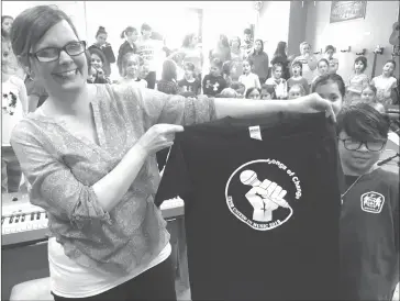  ?? MATTHEW MCCULLY ?? Rivette showing off the shirts that the students will wear at the upcoming concert. The logo for this year’s ESTB United in Music concert was designed by Sherbrooke Elementary School kindergart­en teacher Dana Gillam.