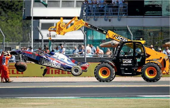  ?? AP ?? Brendon Hartley’s damaged car is removed from the Silverston­e track after the Kiwi driver crashed during practice for the 2018 British Grand Prix.