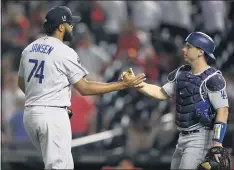  ??  ?? Dodgers closer Kenley Jansen and catcher Will Smith celebrate after the team capped a four-game sweep of Washington, stretching a win streak to eight.