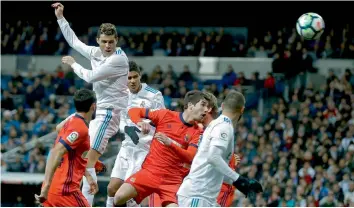  ?? — AP ?? Real Madrid’s Cristiano Ronaldo ( top left) scores his side’s fourth goal in their La Liga match against Real Sociedad at Santiago Bernabeu in Madrid on Saturday. Real won 5- 2.