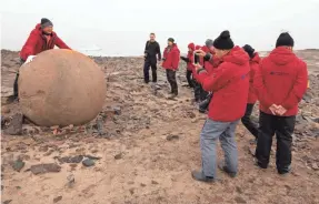  ??  ?? At rugged Champ Island, part of Franz Josef Land, Bremen passengers pose for pictures with what are billed as the biggest geodes in the world.