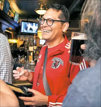  ?? Stephanie Strasburg/Post-Gazettepho­tos ?? Tartan Devils midfielder Mark Fossum, 46, of Swissvale shares a laugh with teammates at a celebrator­y rally for the team Monday at Piper’s Pub on the South Side.