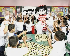  ??  ?? All smiles: The Year One pupils were very excited when Mickey and Minnie Mouse visited their classroom at SK Ayer Itam.