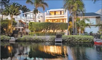  ??  ?? LOCATED ON a Venice canal, Harrison’s 2,800-square-foot home features second- and third-story balconies, a rooftop deck and a waterfront patio under hanging lights. It’s listed at $3.999 million.